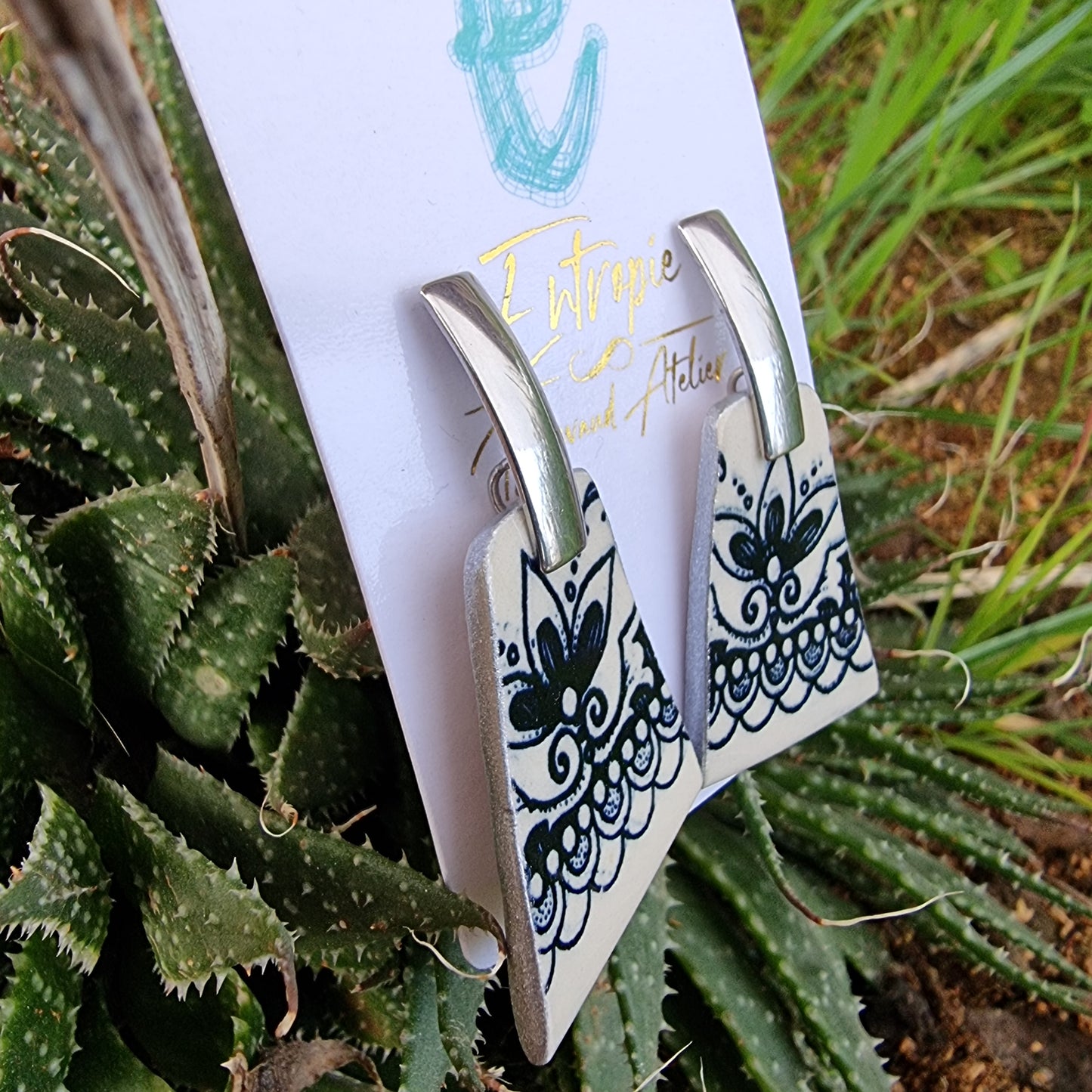 Aros de cerámica chilena, diseño azul y blanco en forma trapezoide.